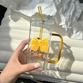 Detail of square glass cup with yellow handle, straw, and 3D bow on white background - Yellow Bow Tie + Straw + Transparent Lid