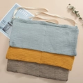 Detail of stacked cotton crib organizers in blue, yellow and grey with soft texture - Assorted Colors