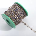 Detail of blue and yellow enamel daisy chain on a roll with 18K gold plated finish - Gold + Ink Blue