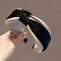 Elegant black and white contrast headband with twisted satin fabric in hand-held view - S90 Black Satin Knot Style
