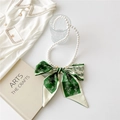 Detail of a pearl necklace with green silk scarf bow accessory on white tabletop - Double Simple Flowers Green