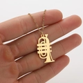 Minimalist gold trumpet pendant necklace with hollow design held by fingers on white background - Golden Trumpet