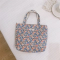 Dettaglio della borsa in tela floreale con etichetta tessuta simple wish e manici robusti - Fiori Rosso Blu