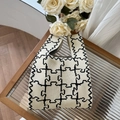 Detail of knitted tote bag with beige and black puzzle pattern on a textured table - Geometric Lines Beige