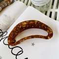 Close-up of tortoiseshell acetate hair claw clip with sparkling rhinestones on a book - Caramel - Colorful Rhinestone Semi-Circle Claw (Approx 11.5cm)