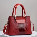 Bolso cubo de charol rojo oscuro con textura de cocodrilo y detalles dorados - Burdeos