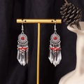 Bohemian silver tassel earrings with red bead accents on a gold jewelry display stand - S4295-1 Red Seed Bead Tassel Earrings