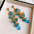 Detalle de pendientes bohemios con borlas, cuentas turquesas y acabado dorado - Oro Azul