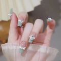 Macro detail of mint green french press-on nails with white pearls and crystal bows - By1506 Lush And Verdant / Glue Type