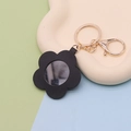 Black leather flower mirror keychain with golden metallic ring on a cloud-shaped tray - Flower Black