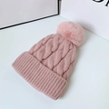 Rosafarbene Strickmütze für Damen mit flauschigem Bommel vor weißem Hintergrund - Einheitsgröße / Rosa