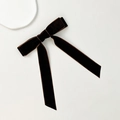 Macro detail of the dark coffee velvet bow hair clip with long elegant streamers - Brown