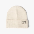 Bonnet en grosse maille côtelée blanc crème avec un écusson lettré tendance d'hiver - Taille unique / Poche zippée