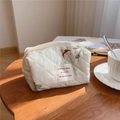 Detail of quilted cotton makeup bag with bear embroidery on a rustic wooden table - Big Bear
