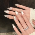 Detailed view of silver cat-eye press-on nails with 3D butterfly rhinestones and pearls - XS / Medium Long Oval Style (968)