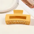 Close-up of a large matte yellow hair claw clip with a hollow rectangular design and grip teeth - 10.5cm Rectangular - Matte Ginger Yellow