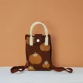 Detailed close-up of dark brown woven phone bag featuring vibrant yellow fruit patterns - Persimmon Good Fortune (Coffee)