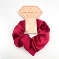 Deep red satin silk scrunchie with diamond-shaped gift tag on white background - Red