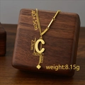 Golden titanium steel letter C tassel necklace with unique chain on a dark wood block - Letter C / Gold