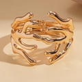 Detail van de gouden organische vloeibare metalen armband met scharnier en hoogglans - Lava Fluïde Stijl Open Armband / Goud