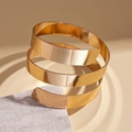 Detalle macro del brazalete de espiral dorado de tres capas con acabado metálico brillante - Dorado