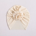 Beige ribbed knit baby turban hat with donut knot decoration on a neutral background - Beige