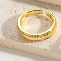 Close-up of gold crescent ring with colorful inlaid stones on beige stone surface - Multicolor Zirconia Style 3 (JZ0375-6)