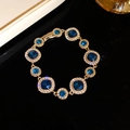 Pulsera vintage dorada con piedras azul zafiro y blancas con borde de cristal brillante - Dorado-Azul