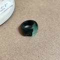 Detailed top view of dark and transparent green resin oval ring on matte brown background - Two-tone Spliced Green