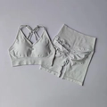 Detailaufnahme von nahtlosem hellgrauem Yoga-Set mit gekreuzten Trägern und Scrunch-Effekt - S / Elfenbeingrau