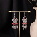 Detail of bohemian drop earrings with red beads and leaf-shaped tassels on a gold stand - Antique Silver Vermilion Beaded Hollow Floral Style (E7664)