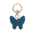 Primer plano de un llavero de mariposa azul con pedrería azul brillante y anillo dorado - Azul