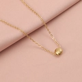 Close-up of a golden shell pendant on a fine chain over soft pink textured fabric - 18K Gold Plated 3#