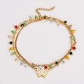 Detail of layered gold ankle bracelet featuring colorful beads and butterfly charm - Bracelet