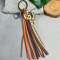 Detail of leopard print cactus keychain with orange and beige multi-color tassels - Leopard Cactus
