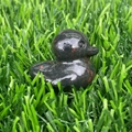 Handcrafted black natural stone duck figurine with red spots on green grass - Plum Blossom Jade