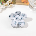 Detail of floral butterfly hair claw clip with blue pattern on white resin surface - 7cm Flower / Light Blue Butterfly