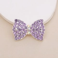 Detailed view of a silver alloy bow charm featuring purple and rainbow rhinestones - D1986 Purple Rhinestone Bow
