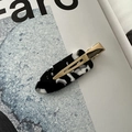 Detail of acetate marble pattern hair clip with gold metal base on minimalist background - No-Crease Hair Clips / Black and White