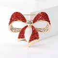 Close-up of red and gold bow brooch with sparkling rhinestones and love heart detail - Red