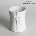 White ceramic aromatherapy burner with brown speckles and 3D bow relief detail - Bow Tie Character Burner