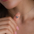 Detail einer silbernen Halskette mit blauem Schmetterling-Opal-Anhänger am Frauenhals - Silber/Blau
