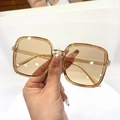 Close-up of stylish square oversized sunglasses with transparent amber acetate frames - Transparent Tea Frame Tea Lens