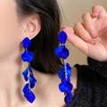 Close-up of royal blue rose petal tassel earrings with long metallic chains on model - Royal Blue Petal Tassel Style / Blue