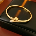 Detail of a gold-plated oval cuff bracelet with a white gemstone on black leather - Gold (Real Gold Plated)