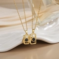 Macro shot of gold-plated camera pendants with projection stones and zircon accents - Gold Camera Projection Necklace XL0285