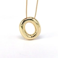 Macro view of a gold-plated circular pendant on a box chain with mirror-polished finish - Letter O