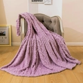 Plush purple cable knit throw blanket with soft texture draped on a gray fabric chair - Monet Purple