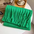 Écharpe épaisse vert émeraude en mohair avec de grosses franges sur table - Vert