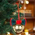 Christmas tree ornament featuring a gold star-cutout bell with a red and green velvet bow - Green and Red Bowtie Style